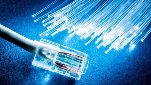 Network cable and optical fibers with lights on blue background