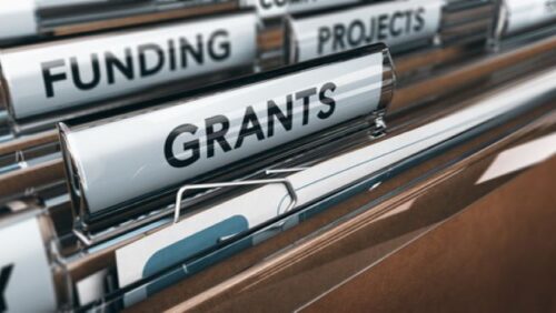 View of brown folders with focus on grants label Concept of funding 3 D illustration
