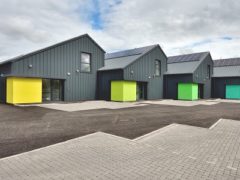 This is an image of grey coloured buildings with colourful entrances.
