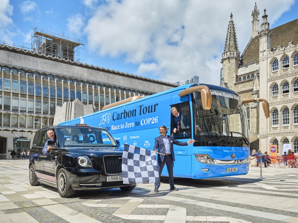 Blue electric bus with 'Zero Carbon Tour' written on its side.
