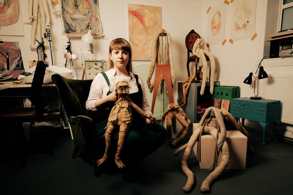 Woman holding artistic objects.